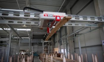 Die neue Anlage beschleunigt das Massivholzhandling bei der Feil GmbH in Siegsdorf. Die Spezialtraverse integriert einen Laserscanner sowie eine Abstreifmechanik. Bild: Barbaric
