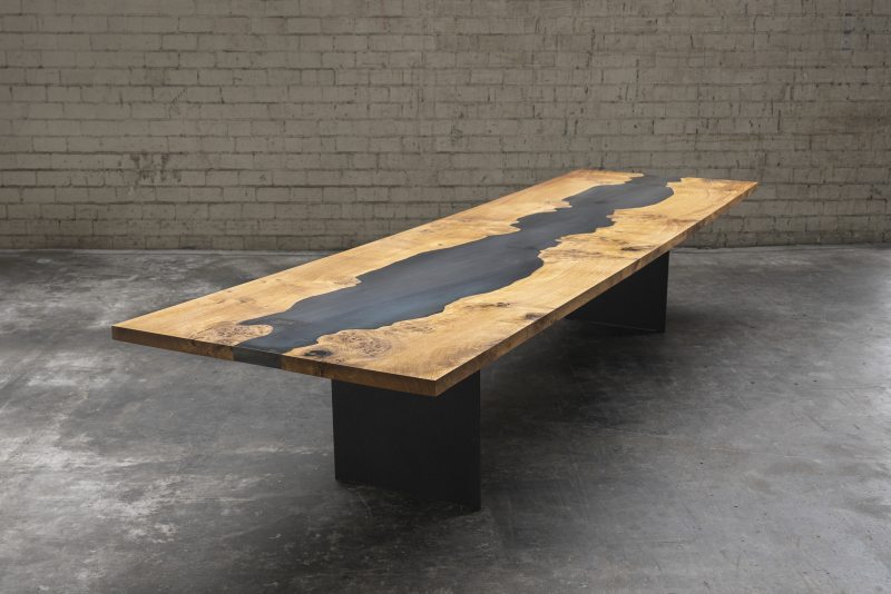 Für die Stahlplatte in der Tischmitte wurde die Kontur der Waldkante einer Eiche Maser nachgefräst und auf die robuste Stahlplatte übertragen (Bild: Schorn & Groh).