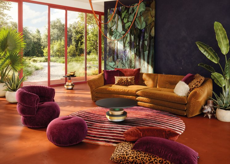 Das mit weichem Velours bezogene Sofa strahlt dank der übereinander gestapelten Kissen eine gewisse Verspieltheit aus (Bild: Bretz).