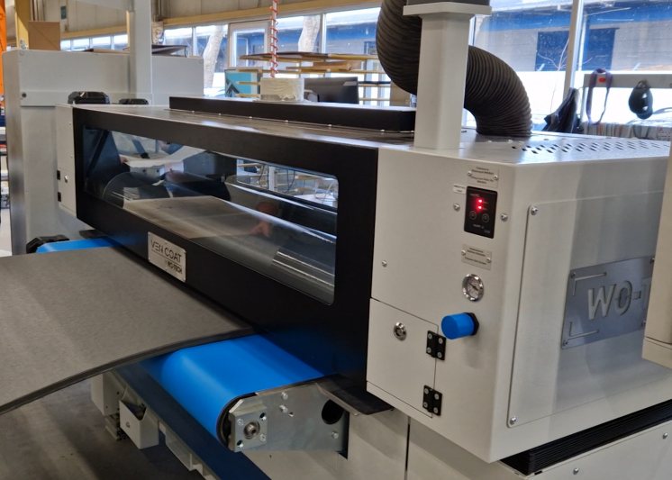Schaumstoff wird auf dem Förderband in die Maschine eingefördert, der Schmelzkleber wird appliziert (Bild: Vanjakob).