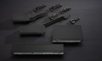 Die dunklen Beschläge umfassen Scharniere, Klappenbeschläge und Boxsysteme für eine durchgängige Gestaltung von Küchenmöbeln (Bild: Blum).
