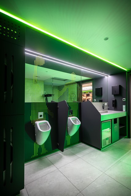 Mit indirekten Lichtlinien von Häfele Lighting erhält der Sanitärbereich eine hochwertige Atmosphäre. Die grüneAkzentbeleuchtung greift zugleich die Vereinsfarben des BBC Bayreuth auf (Bild: Sebastian Kosowski für Schreinerei Stahlmann).